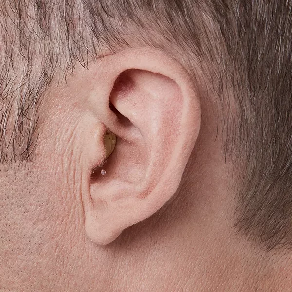 Oticon_Opn_CIC_C001Beige_Angle90_Close-up_In-On-Ear_MS_6852_Man_1200x800px_Original-file.webp