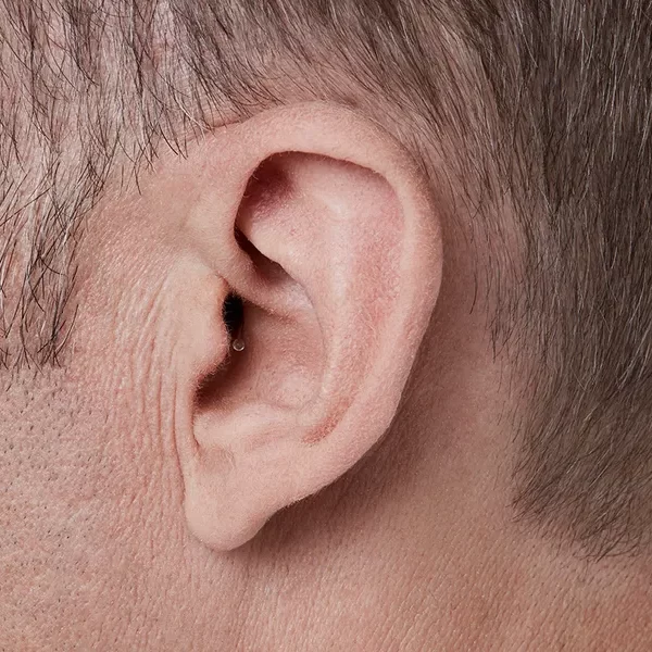 Oticon_Opn_IIC_C001Beige_Angle90_Close-up_In-On-Ear_MS_6861_Man_1200x800px_Original-file.webp